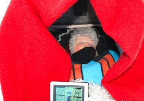 Một đứa trẻ ngủ trong xe nôi ngoài trời có gắn thiết bị  giám sát điện tử trong thời tiết xuống tới -10°C.