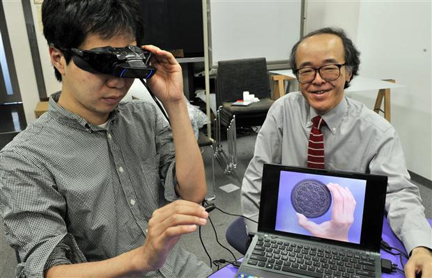 Giáo sư Michitaka Hirose bên cạnh sản phẩm kính mắt đánh lừa