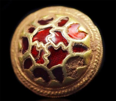 Gold button with red stone.
