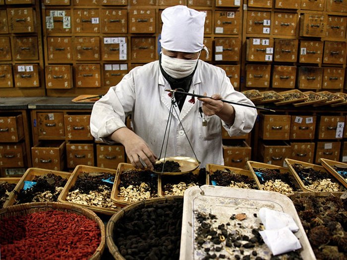 Một thầy đông y Trung Quốc đang cân thuốc. 