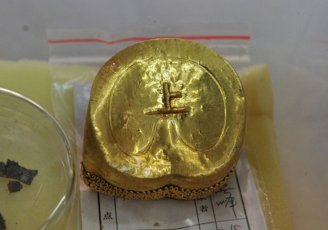 A gold ingot inscribed with the character "Shang". 