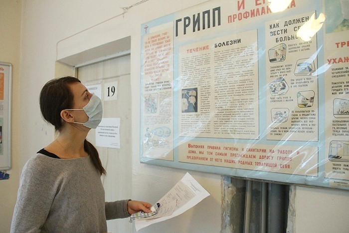 Một phụ nữ đang đọc hướng dẫn phòng tránh bệnh cúm.