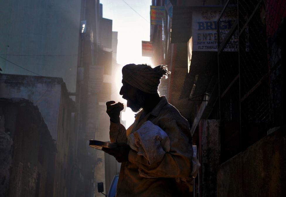 Ấn Độ: Một người đàn ông vô gia cư ăn sáng trên đường phố Bengaluru ngày 25-11