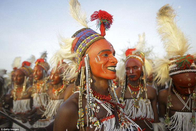 Men paint their faces with red clay, apply black eye makeup, and use lip color to showcase their teeth during the Yaake dance.