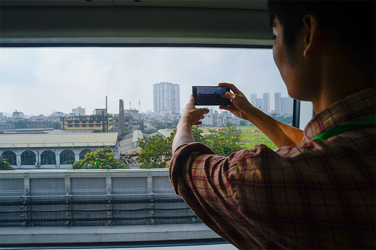 Nhiều người thích thú chụp ảnh cảnh Hà Nội từ bên trong toa tàu.