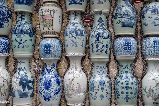 Bức tường được ốp bằng những bình sứ, những viên ngói, những món đồ cổ với sắc màu...