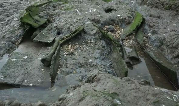  Quan tài mở và xương nằm rải rác trên bãi bùn. 