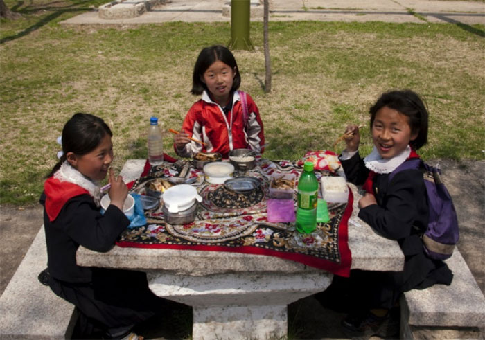  Ba nữ sinh thưởng thức bữa ăn ngoài trời tại một công viên ở Bình Nhưỡng. 