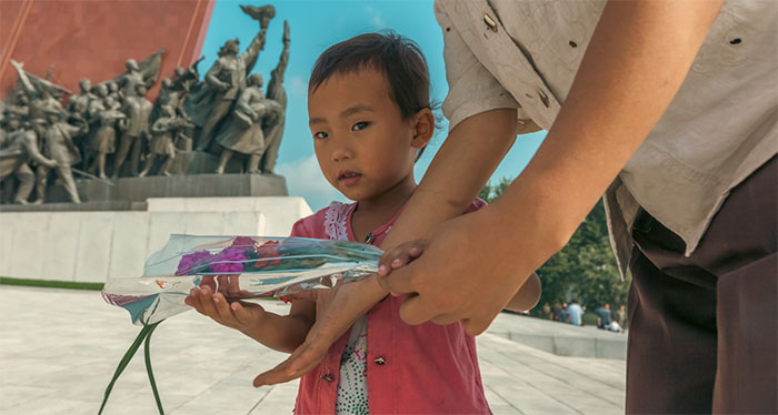 Bé gái được mẹ đưa đến thăm Đài tưởng niệm lớn ở đồi Mansudae, Bình Nhưỡng.