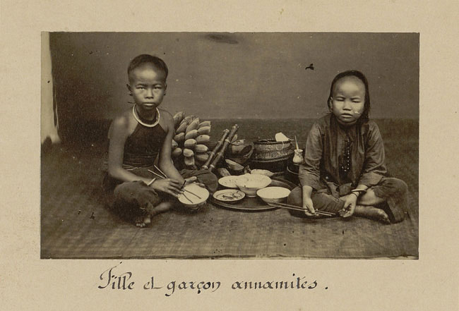 Một bé gái (trái) và bé trai (phải) bên mâm cơm