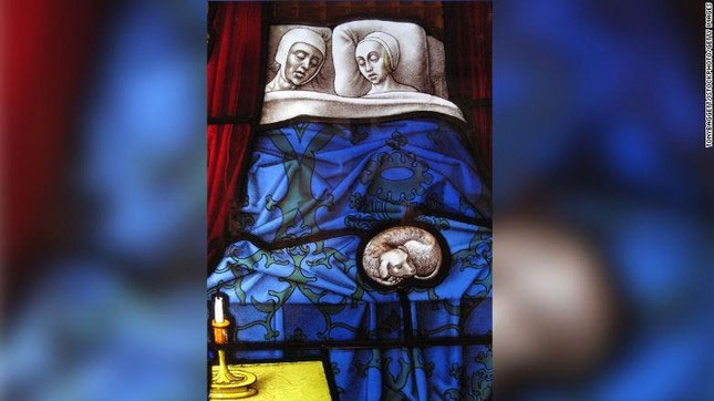 Hình ảnh một cặp vợ chồng đang ngủ trên cửa kính của nhà thờ.
