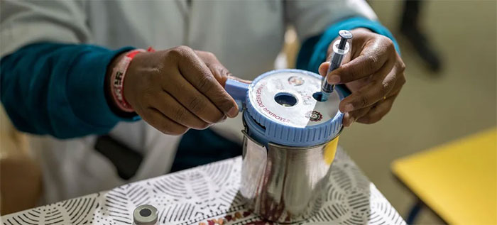 Nhân viên y tế bỏ ống tiêm vaccine Covid-19 đã qua sử dụng vào hộp đựng.
