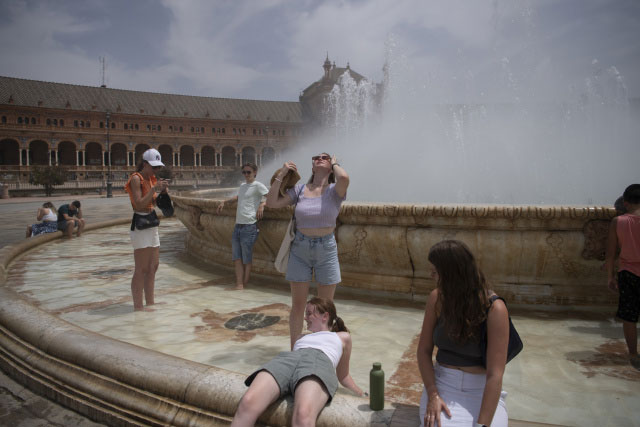 Người dân giải nhiệt ở đài phun trong đợt nắng nóng ở Seville, Tây Ban Nha.
