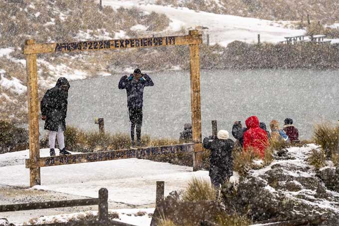 Trong ảnh, du khách chụp ảnh lưu niệm dưới tuyết rơi dày đặc.
