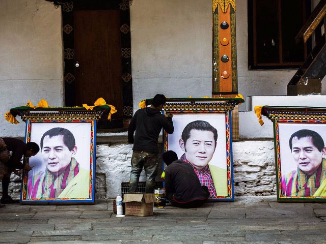 Trong ảnh là các công nhân đang chuẩn bị các bức chân dung của cựu vương Bhutan