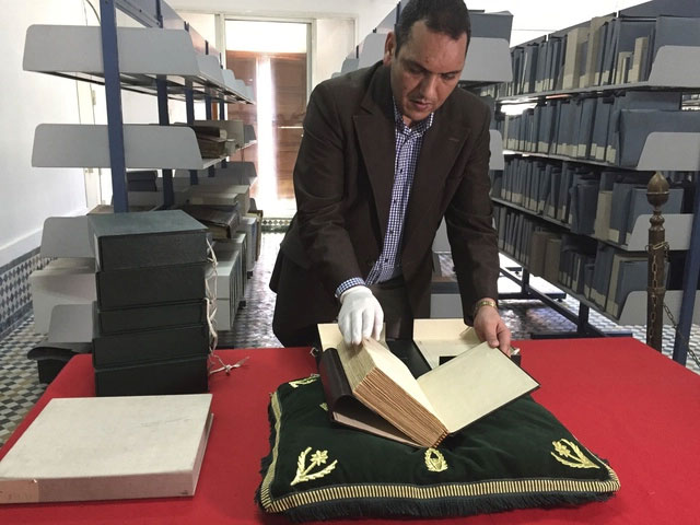 Ông Abdelfattah Bougchouf - người phụ trách Al-Qarawiyyin đang mở một cuốn sách cổ tại thư viện