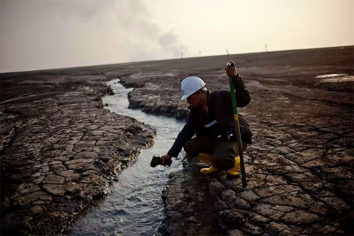Một nhân viên tại Sidoarjo đang kiểm tra nhiệt độ nước gần núi lửa bùn Lusi vào năm 2011.