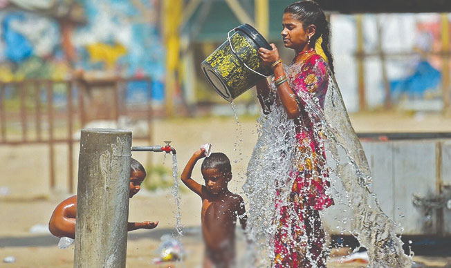  Người dân giải nhiệt tại một vòi nước công cộng trong thời tiết nắng nóng ở Ấn Độ