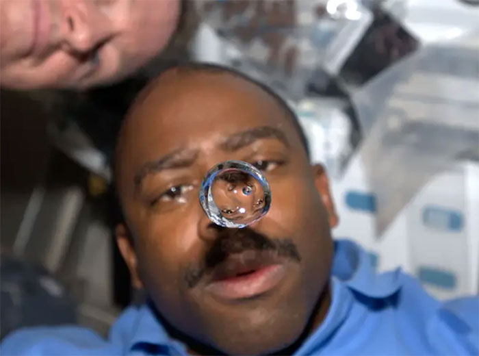 Nhà du hành Leland Melvin đang nhìn một giọt nước trôi lơ lửng trong boong tàu con thoi