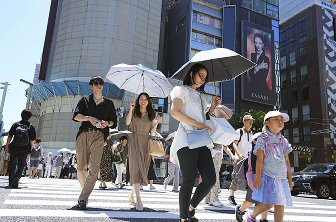 Người dân di chuyển trên đường phố dưới trời nắng nóng tại Tokyo, Nhật Bản, ngày 16/7.