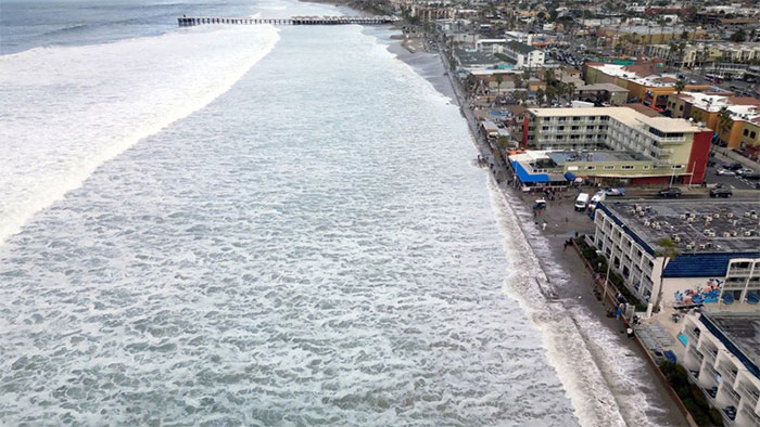 Sóng tràn lên lối đi bộ lát ván tại Bãi biển Mission ở San Diego