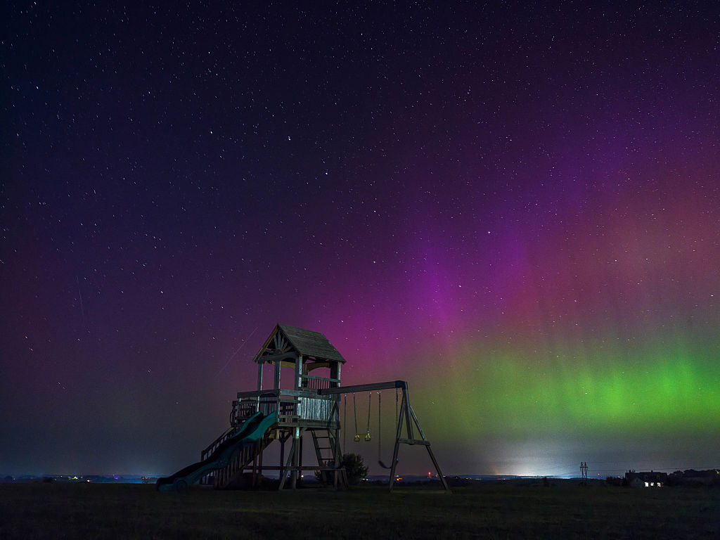 northern lights above southern wisconsin appearing as curtains and pillars of magenta and green light.