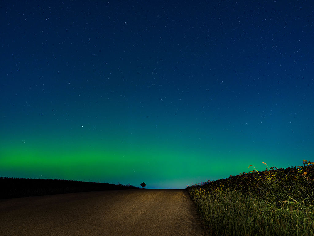 northern lights above southern wisconsin appearing as curtains and pillars of magenta and green light.